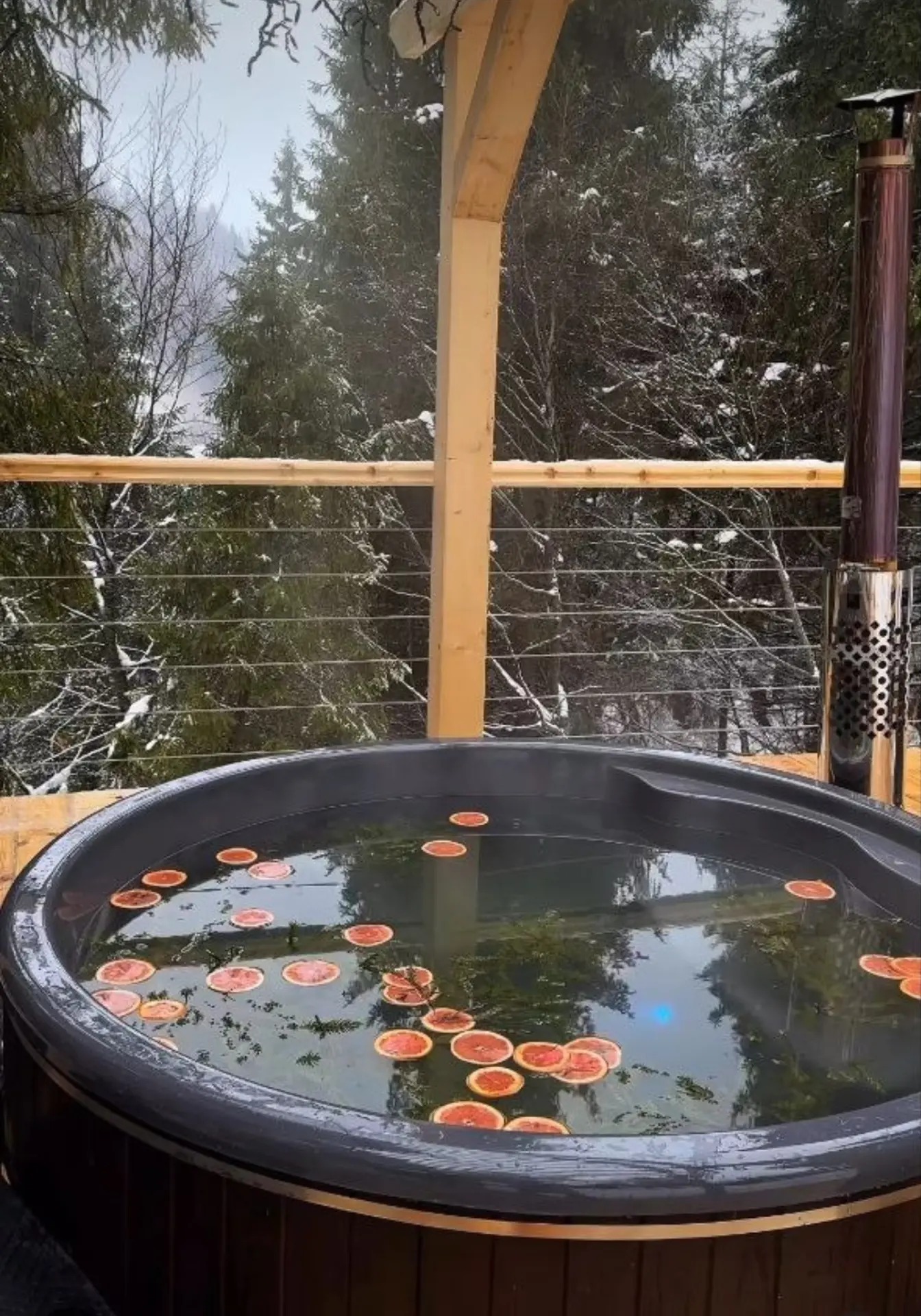 Outdoor thermal tub on a terrace facing the winter forest